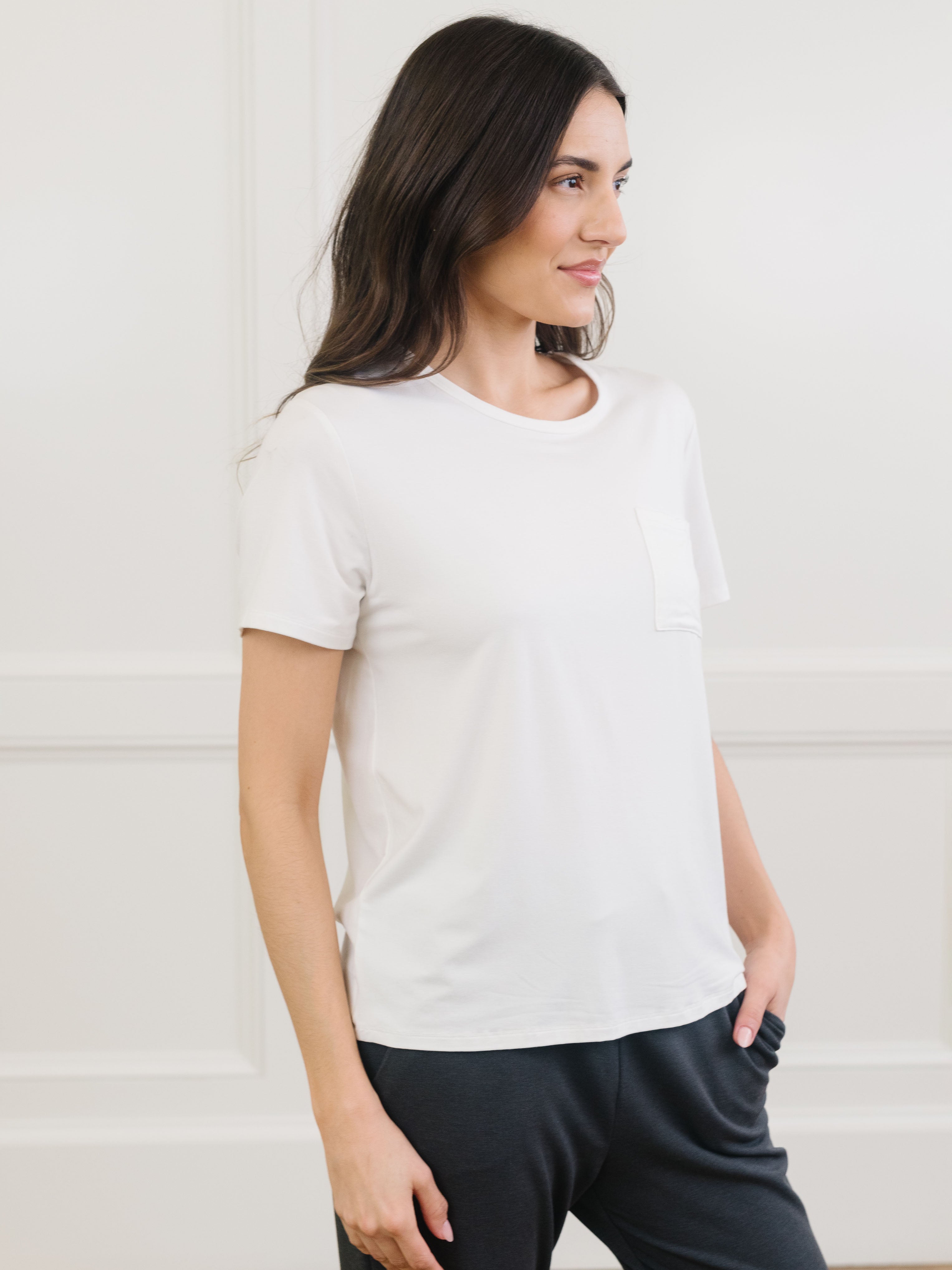 Woman wearing a white t-shirt and dark pants against a light background |Color:Ivory